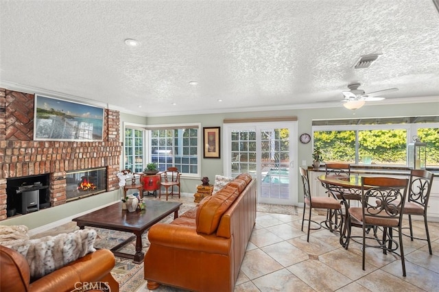 living room with crown molding, a textured ceiling, a healthy amount of sunlight, and a fireplace