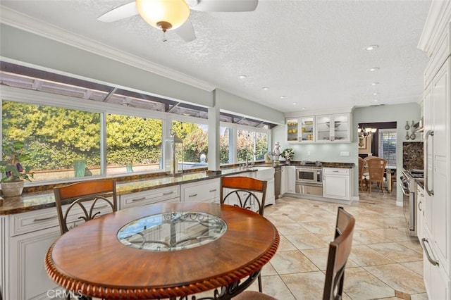 sunroom featuring sink and ceiling fan with notable chandelier