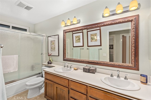 bathroom featuring double vanity, visible vents, combined bath / shower with glass door, and a sink
