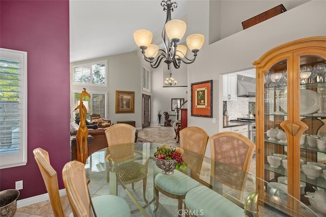 dining area featuring light tile patterned floors, a notable chandelier, and high vaulted ceiling