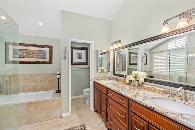 bathroom featuring vaulted ceiling, tile patterned flooring, vanity, toilet, and tiled tub