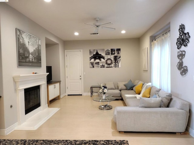 living room featuring light hardwood / wood-style floors and ceiling fan