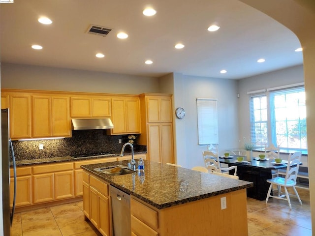 kitchen featuring appliances with stainless steel finishes, sink, a center island with sink, and dark stone counters