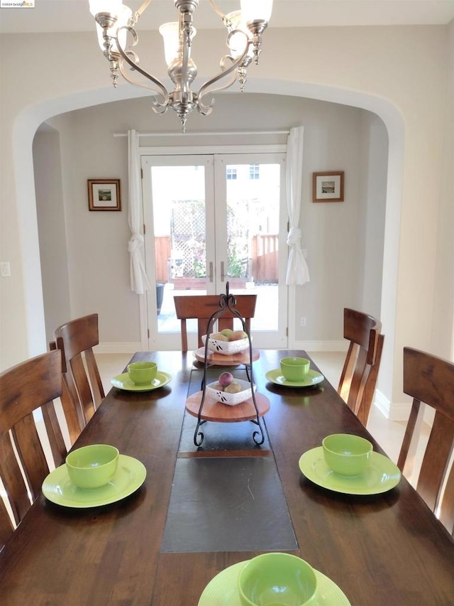 dining area featuring hardwood / wood-style floors, a chandelier, and french doors