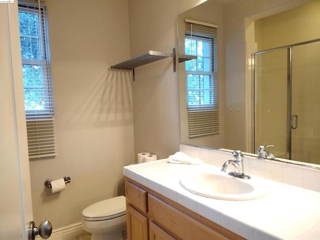 bathroom featuring an enclosed shower, vanity, and toilet