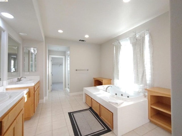 bathroom with tile patterned floors, vanity, and a tub