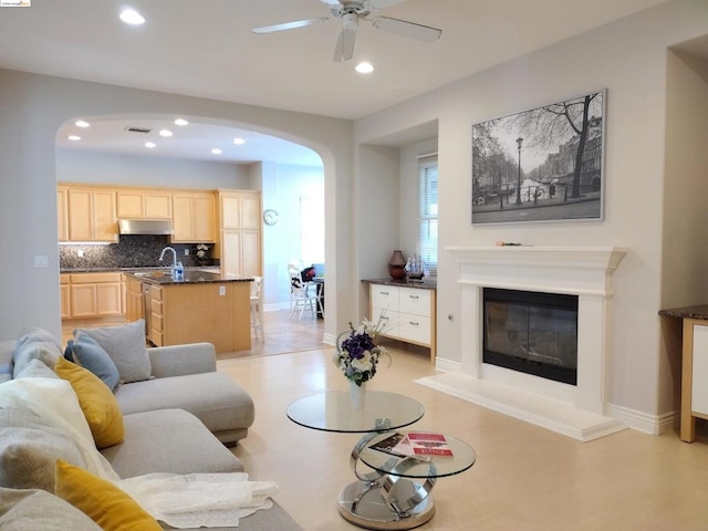 living room featuring ceiling fan and sink