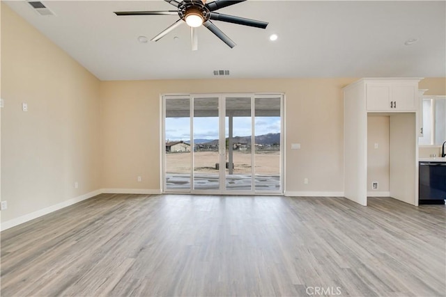 unfurnished living room featuring ceiling fan and light hardwood / wood-style floors