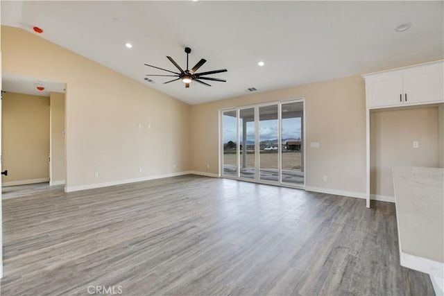 unfurnished living room with lofted ceiling, light wood-type flooring, and ceiling fan