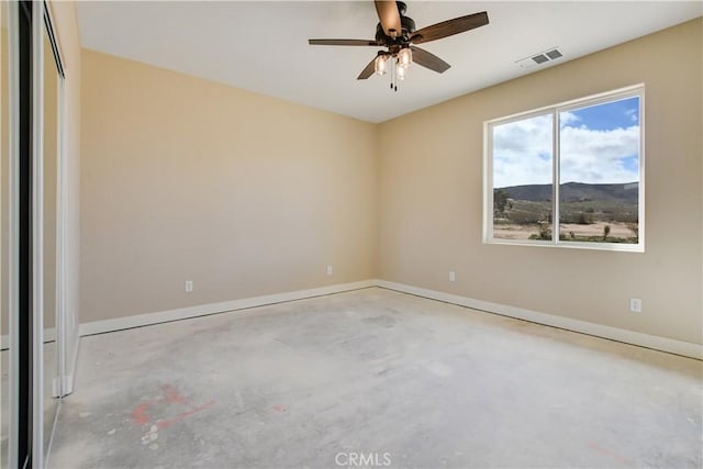 unfurnished room featuring ceiling fan and a mountain view