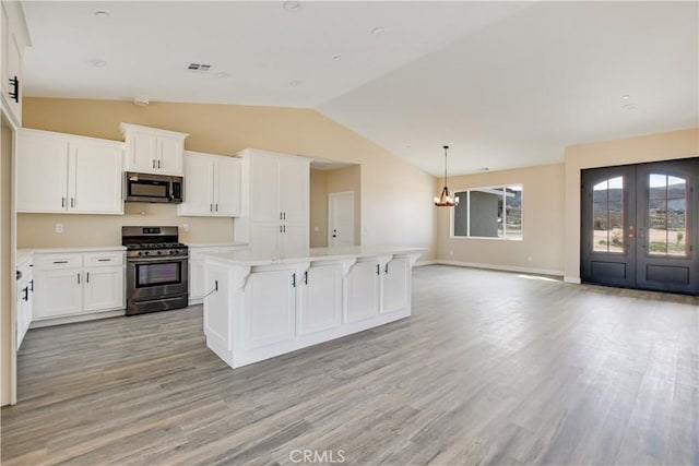 kitchen featuring a kitchen island, white cabinetry, appliances with stainless steel finishes, and french doors