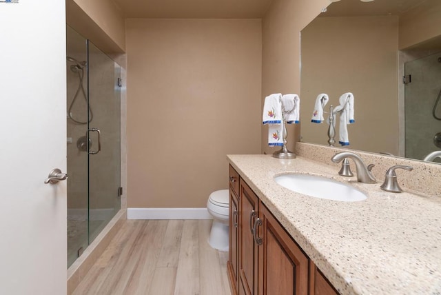 bathroom featuring hardwood / wood-style flooring, vanity, toilet, and walk in shower