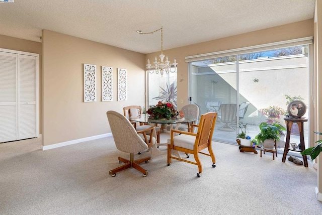 carpeted dining room featuring a textured ceiling and an inviting chandelier