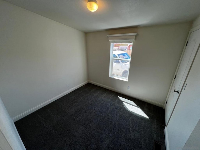 empty room featuring dark colored carpet