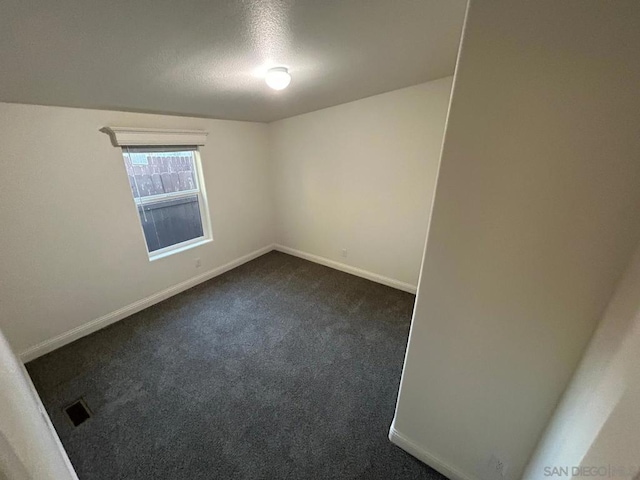 carpeted empty room with a textured ceiling