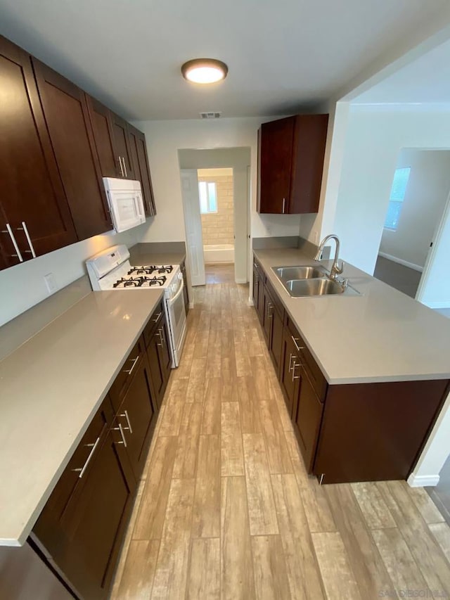 kitchen featuring sink, white appliances, and light hardwood / wood-style flooring