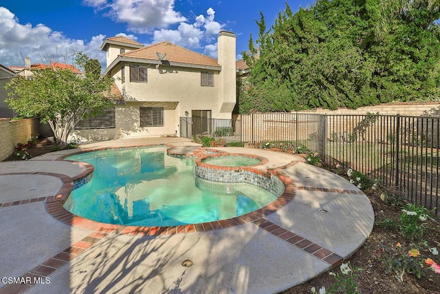 view of swimming pool featuring a patio and an in ground hot tub