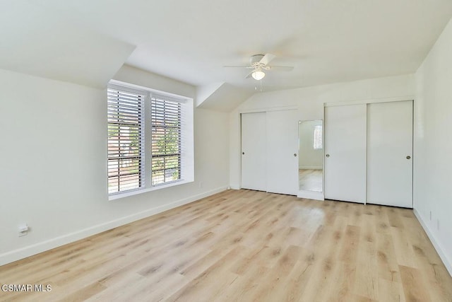 unfurnished bedroom with ceiling fan, two closets, and light hardwood / wood-style floors