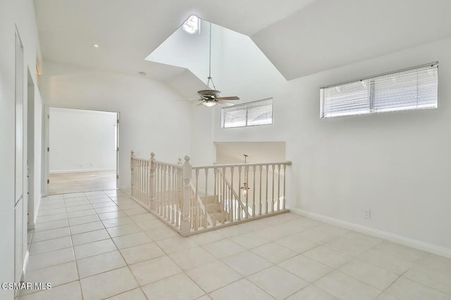 spare room with lofted ceiling, light tile patterned floors, and ceiling fan