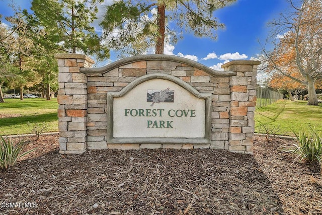 community / neighborhood sign featuring a yard