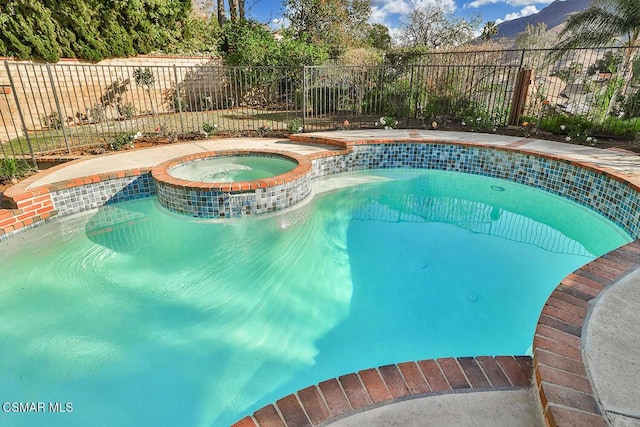 view of swimming pool with an in ground hot tub