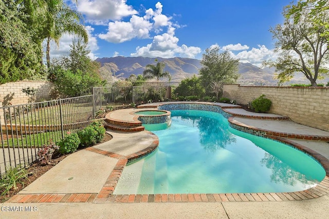 view of pool featuring a mountain view and an in ground hot tub