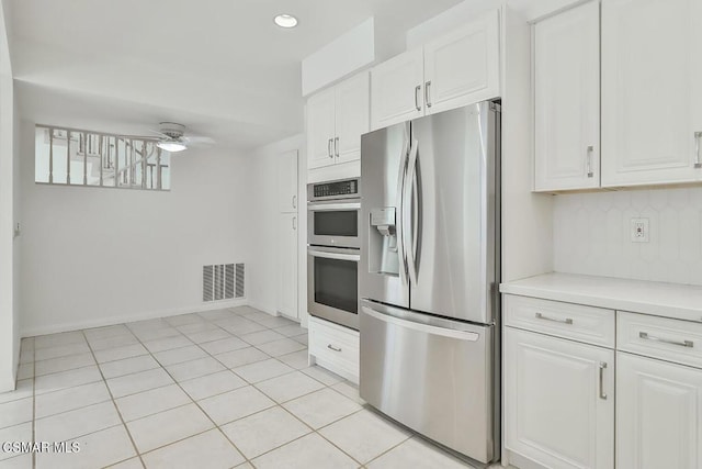 kitchen with ceiling fan, decorative backsplash, stainless steel appliances, and white cabinets