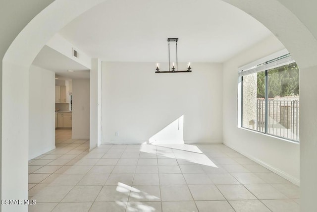 unfurnished dining area featuring an inviting chandelier and light tile patterned floors