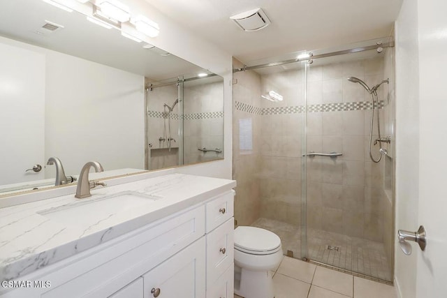 bathroom featuring tile patterned floors, vanity, toilet, and a shower with door