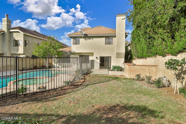 back of house with a fenced in pool, a yard, and cooling unit