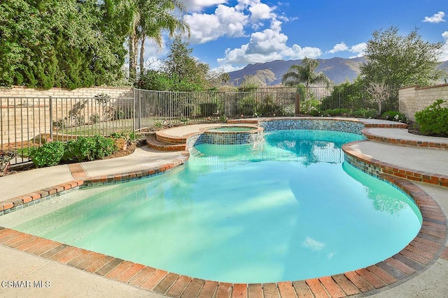 view of swimming pool featuring a mountain view and an in ground hot tub