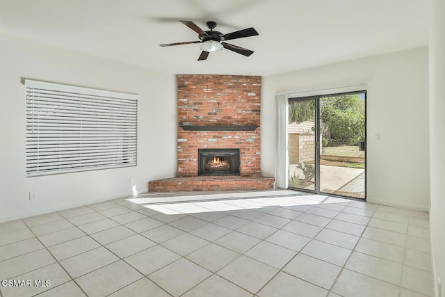 unfurnished living room featuring ceiling fan, a brick fireplace, and light tile patterned floors