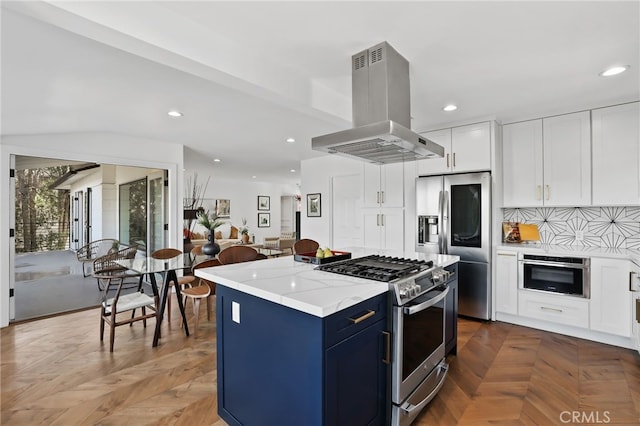 kitchen featuring parquet flooring, appliances with stainless steel finishes, a kitchen island, island exhaust hood, and white cabinets