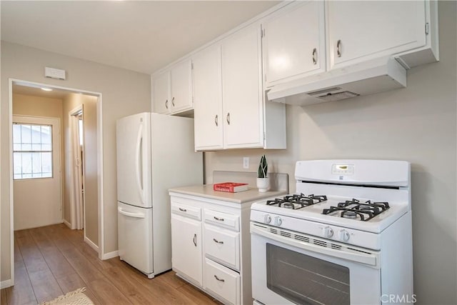 kitchen with white appliances, light hardwood / wood-style flooring, and white cabinets