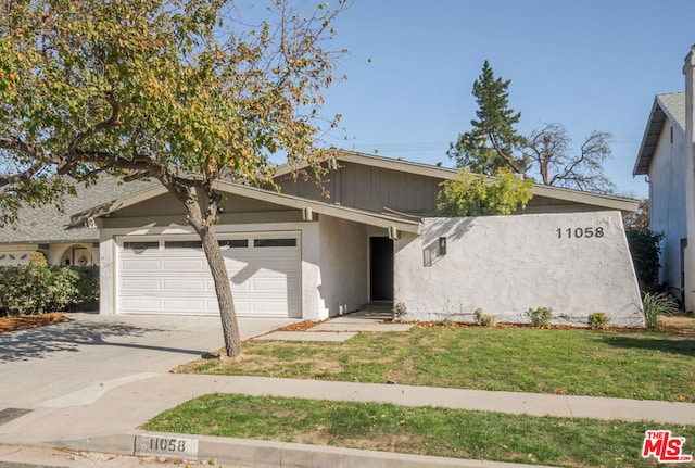 view of front of house with a garage and a front lawn