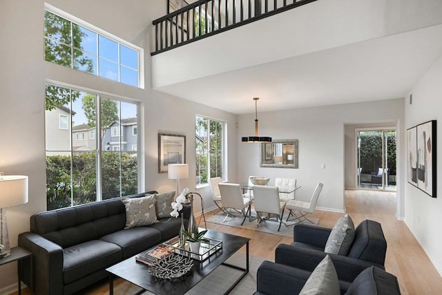 living room with a towering ceiling and light hardwood / wood-style floors