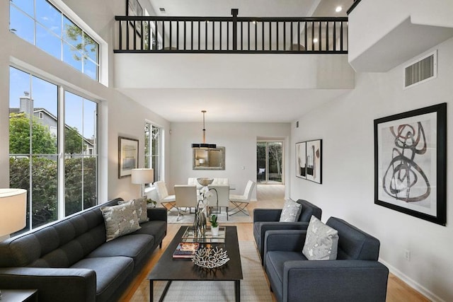 living room with wood-type flooring and a high ceiling