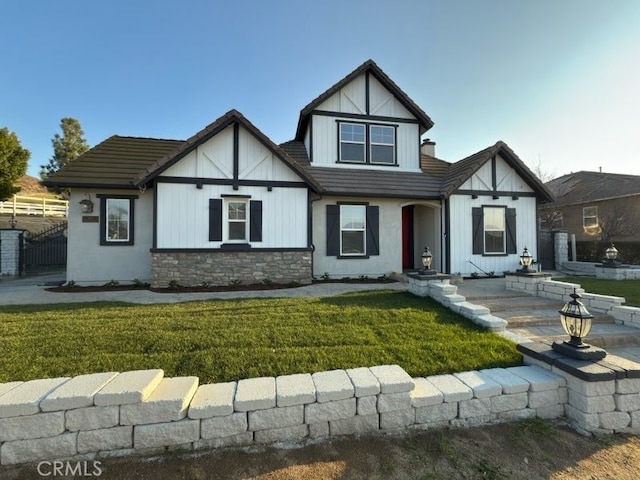 tudor-style house featuring a front yard