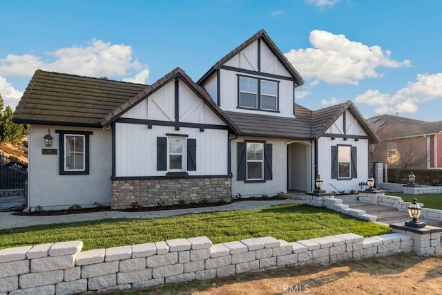 tudor-style house featuring a front yard