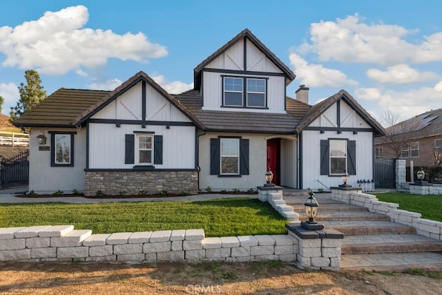 tudor-style house featuring a front lawn