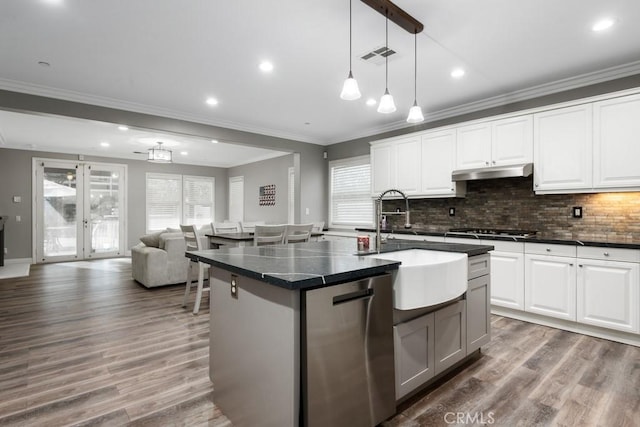 kitchen with a kitchen island with sink, white cabinets, and appliances with stainless steel finishes