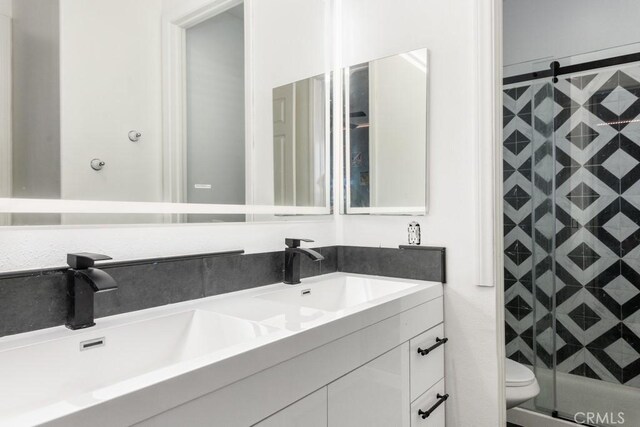 bathroom with vanity, a tile shower, and toilet