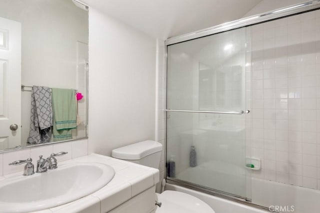 full bathroom with enclosed tub / shower combo, vanity, and toilet