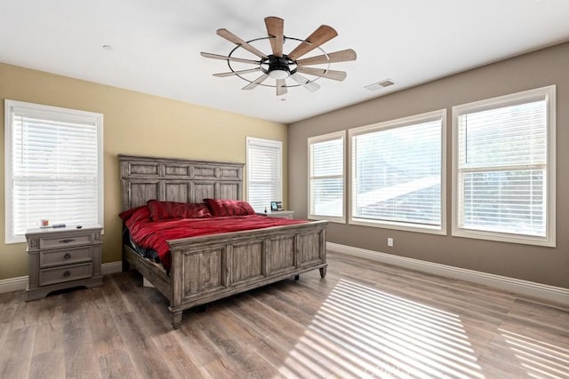 bedroom with multiple windows and wood-type flooring