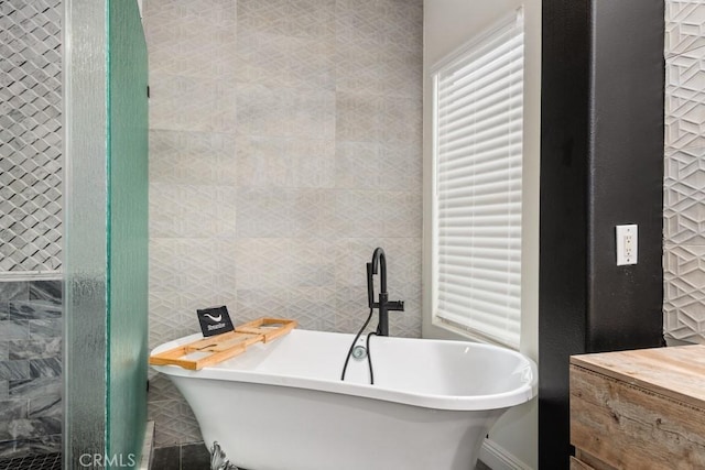 bathroom featuring tile walls and a bathing tub