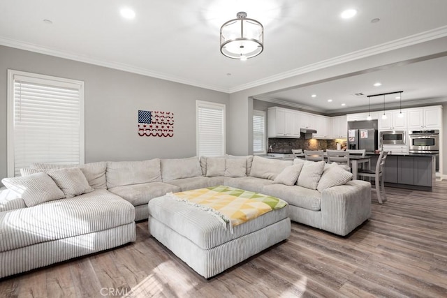 living room featuring crown molding and light hardwood / wood-style flooring