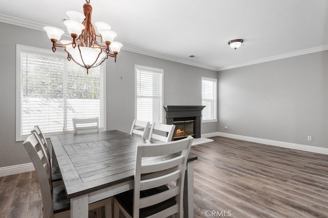 dining room featuring crown molding, dark hardwood / wood-style flooring, and a chandelier