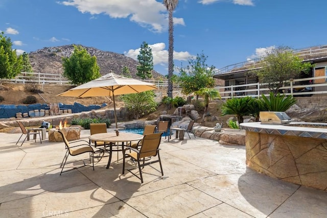 view of patio with area for grilling and a mountain view