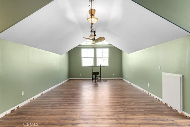 additional living space featuring dark wood-type flooring, ceiling fan, and vaulted ceiling