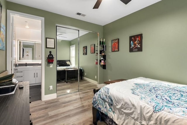 bedroom featuring connected bathroom, sink, a closet, ceiling fan, and light hardwood / wood-style floors